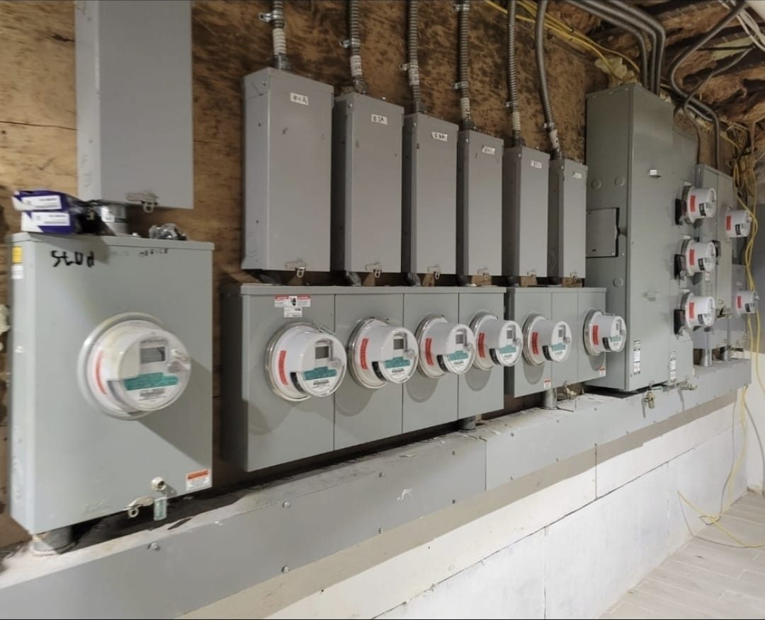 Bank of electric meters and disconnects on a multifamily building wall