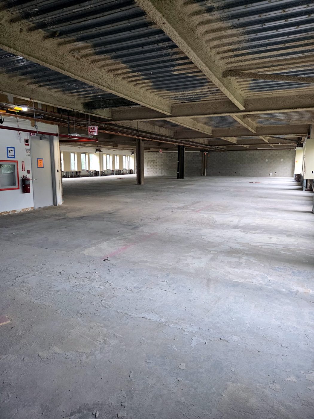 Open raw floor plate with exposed structure before build-out