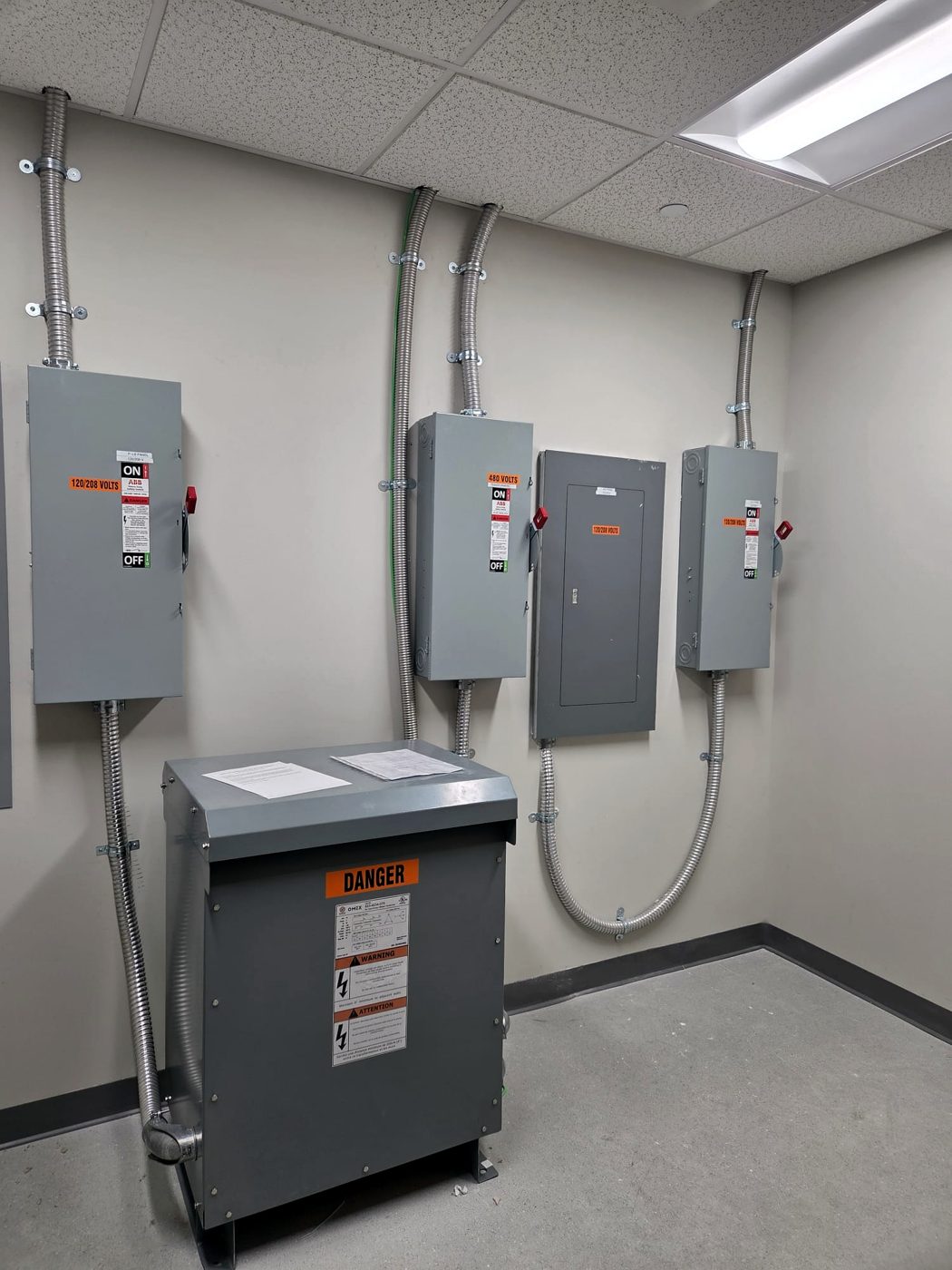 Disconnects, panels and a dry-type transformer in a commercial electrical room