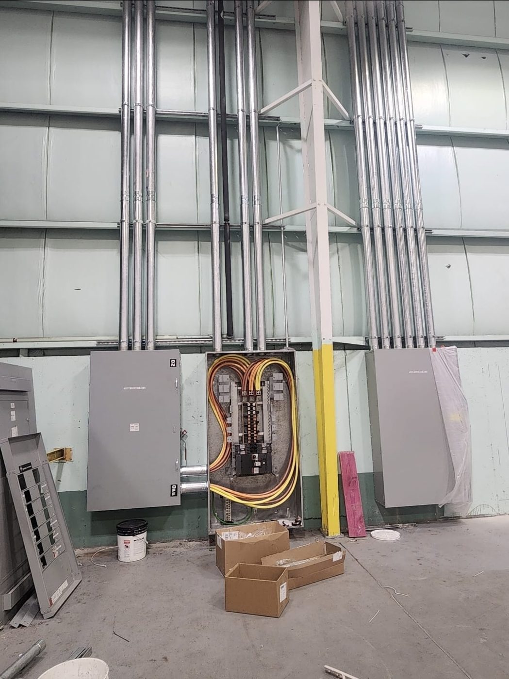 Warehouse wall with conduit risers feeding distribution panels