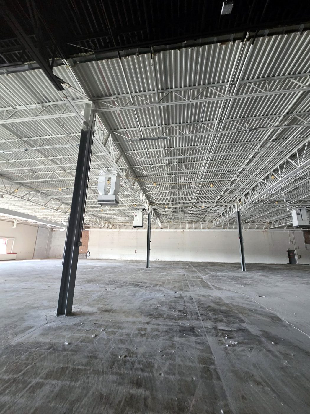 Large open warehouse shell with overhead structure and HVAC